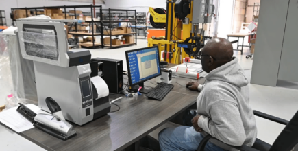 Our expert Floor Manager operating the labeling machine on the manufacturing floor.